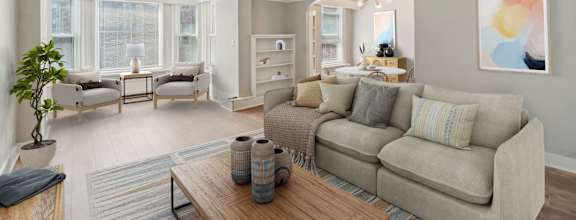 A living room with a couch, a coffee table, and a potted plant.