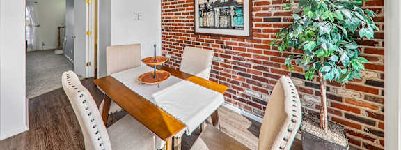 A dining room with a wooden table and chairs.
