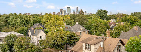 A city skyline is visible in the distance behind a row of houses.