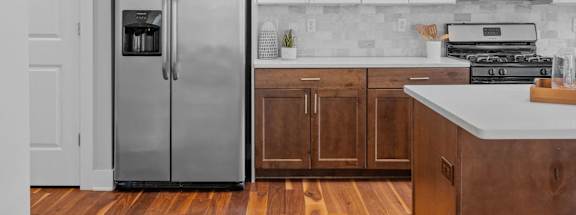 A kitchen with a refrigerator, microwave, and oven.