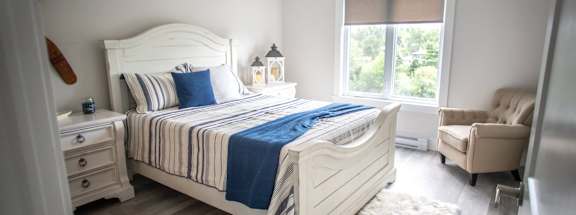 a bedroom with a bed and a chair and a window