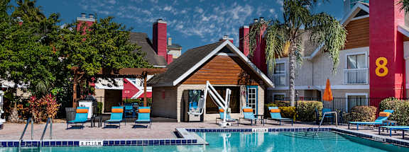 A pool with a wooden building in front of it at Fusion Orlando furnished apartments.