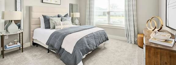 A bedroom with a large bed and a ceiling fan.