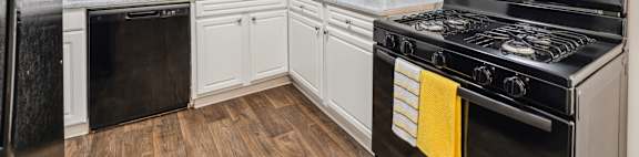 A kitchen with white cabinets and a black stove top oven.