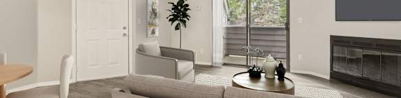 A living room with a grey couch and a wooden table.