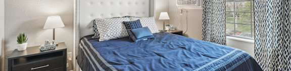 A bedroom with a large bed and a ceiling fan.