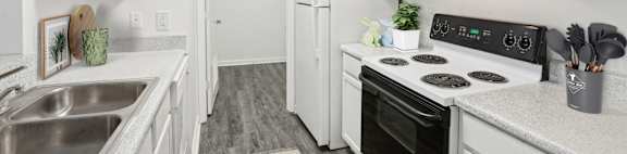 A kitchen with white cabinets and a black stove top oven.