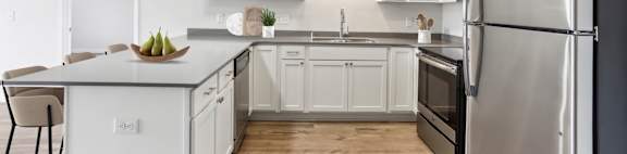 A modern kitchen with a large island and stainless steel appliances.