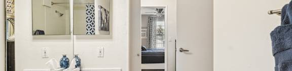 A bathroom with a white sink and a mirror above it.