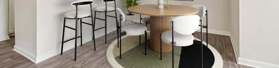 A kitchen with a bar and a dining table with chairs.