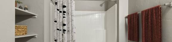 A white bathroom with a toilet, sink, and shower.