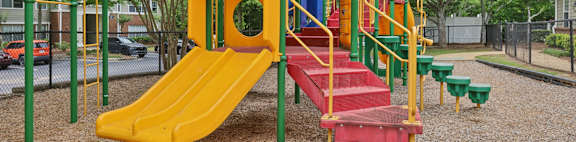 A playground with a yellow slide and a blue roof.