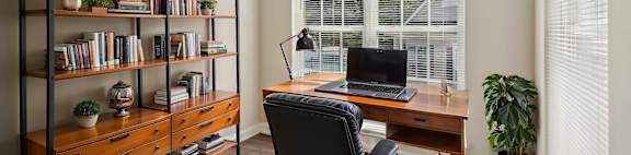 A room with a desk, chair, and bookshelf.