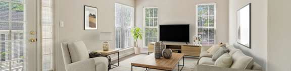 A living room with a couch, chair, and television.