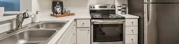 A kitchen with white cabinets and stainless steel appliances.
