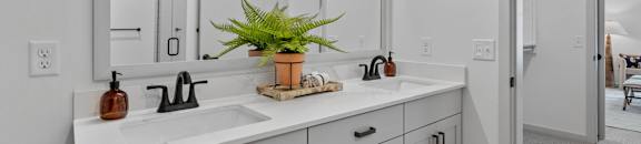 a white bathroom with two sinks and a large mirror