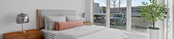 a bedroom with a bed and a large window