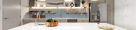 A modern kitchen with a white countertop and pendant lights.