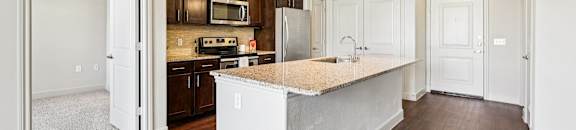 A kitchen with a white island in the middle of the room.