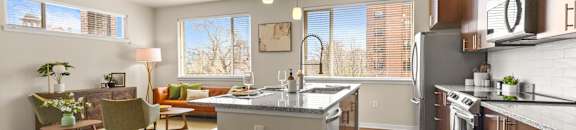 a large kitchen with an island and a dining room with a table and chairs