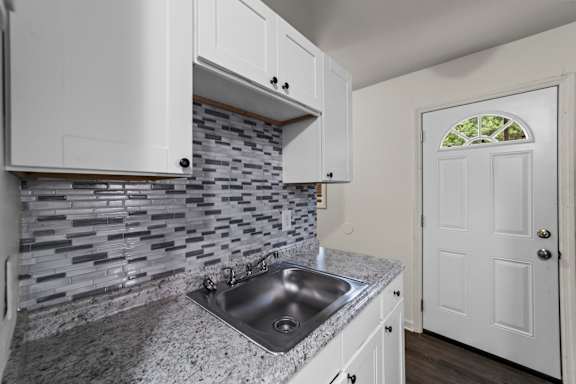 A kitchen with a sink and a door.