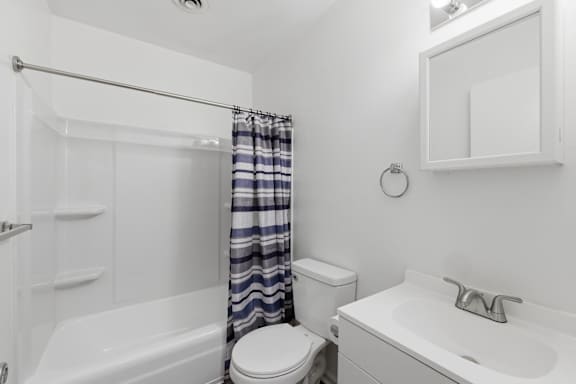 A white bathroom with a toilet, sink, and bathtub.