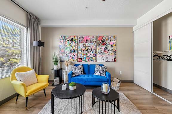 A living room with a yellow chair and a blue couch.