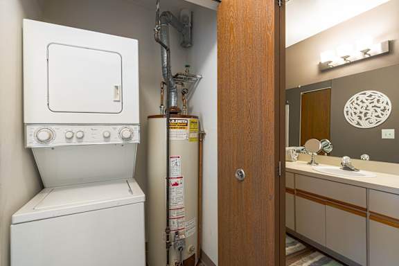 a laundry room with a washer and dryer and a bathroom with a sink