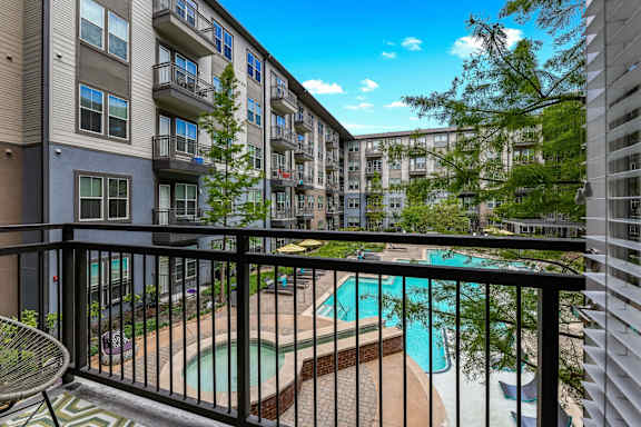 A balcony with a pool and a chair.