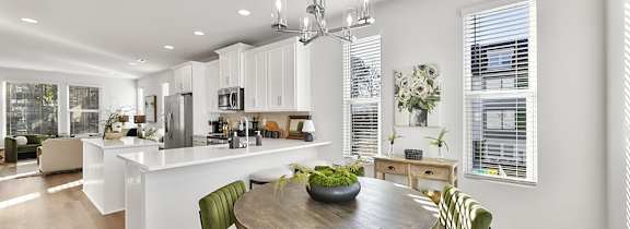 A modern kitchen with a dining table and chairs.