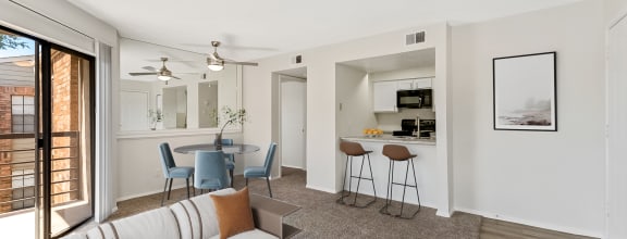 a living room with a couch and a table with chairs at The Hudson, North Richland Hills, TX