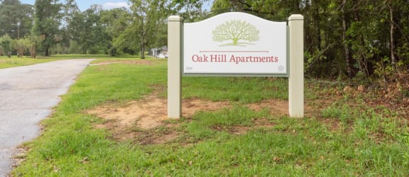 a sign with oak hill apartments written on it