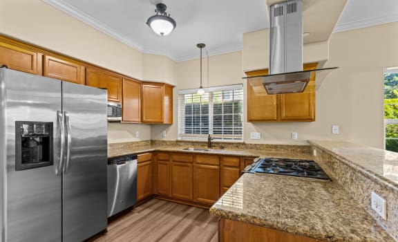 an updated kitchen with stainless steel appliances and granite counter tops