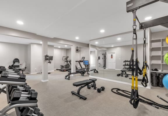 the gym at the flats at obsidiancontinued furnished workout room with weights