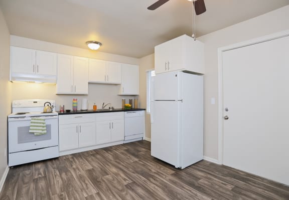 spacious kitchen with white cabinets and appliances with a ceiling fan  at Woodhaven, Everett, 98203