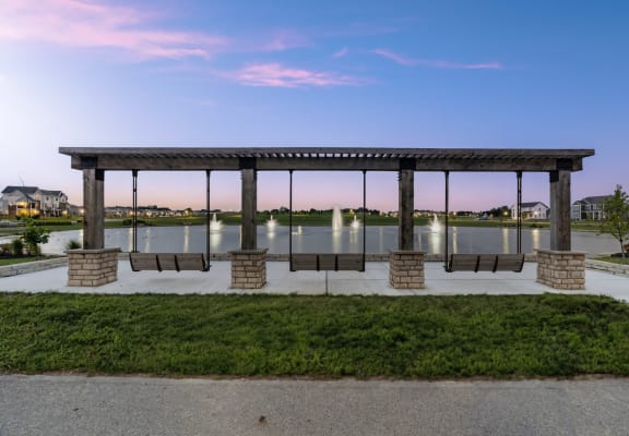a pavilion with benches in front of a body of water