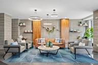 A modern living room with a blue rug and grey chairs.