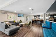 A modern living room with a grey sofa and a blue bench.