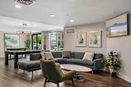 A living room with a grey couch and a green armchair.