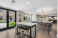 A modern kitchen with a long table and bar stools.