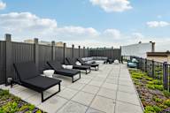 A patio with black chairs and a table.