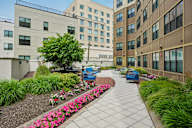 A walkway with a flower bed in front of apartment buildings.