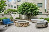 A patio with a fire pit and seating area.