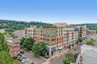 A large multi-story building with a parking lot in front.