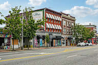 A street view of a city with a building that has a sign that says "The Loftice".