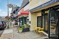 A street view of a cafe with a red and white striped awning.