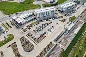 A parking lot with cars and a train track running through it.