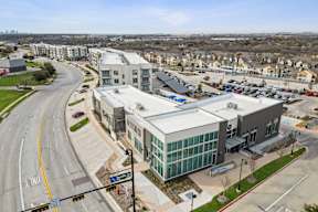 A modern building with a parking lot in front of it.