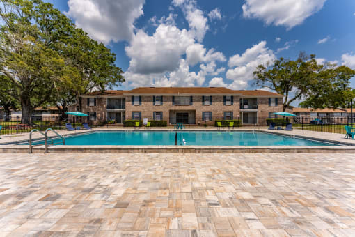 a swimming pool with a building in the background at Jacksonville Heights Apartments