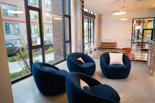 a group of blue chairs in a room with large windows